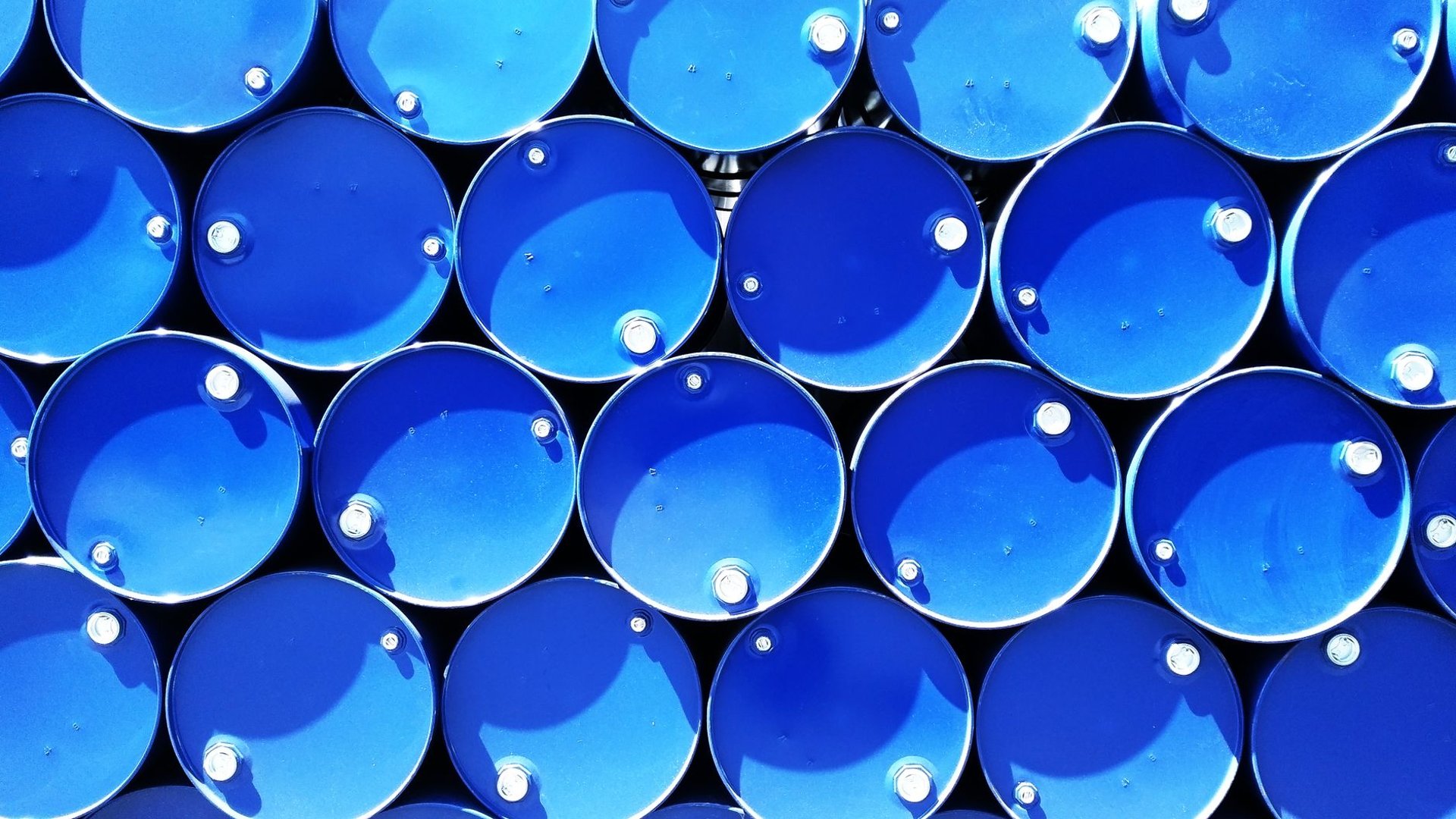 Gestapelte blaue Stahlfässer für Öle und Chemikalien, die eine Auffangwanne als Rückhaltung brauchen